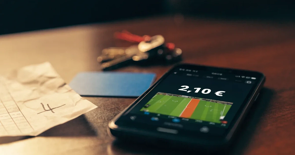 Ein Smartphone mit dunklem Display liegt neben einer Geldbörse und einem Schlüssel auf einem Tisch.
